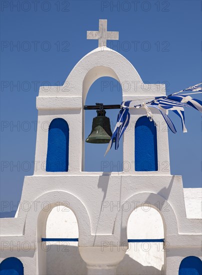 White bell tower with Greek flags