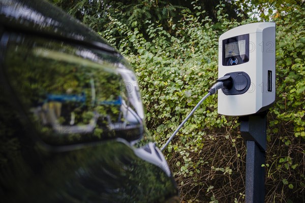 An e-car being charged at a private charging station