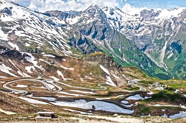 Photo with reduced dynamic saturation HDR of mountain pass alpine mountain road alpine road pass road pass old Grossglockner High Alpine Road Grossglockner High Alpine Road with serpentine switchbacks curves above above tree line
