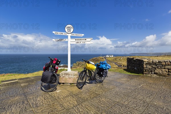 Two e-bikes at the famous signpost to New York