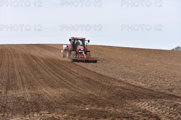 Tractor with seed drill in a field