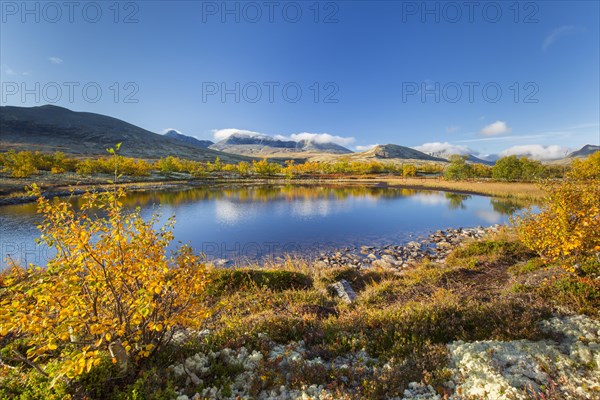 The mountains Hogronden and Digerronden reflected in water of lake in autumn