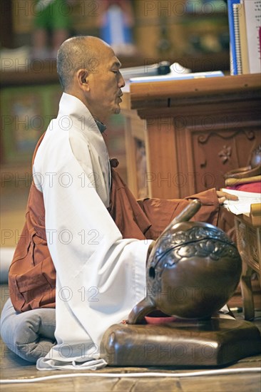 Korean monk praying in the prayer hall