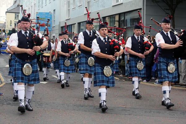 Irish bagpipers in kilts march at the head of the final parade to mark the close of Fleadh Cheoil na hEireann