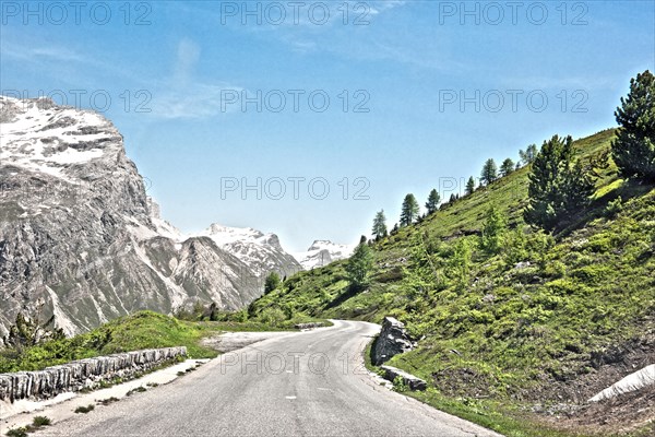 Photo with reduced dynamic range saturation HDR of mountain pass alpine mountain road alpine road pass road pass near tree line in landscape of high alps