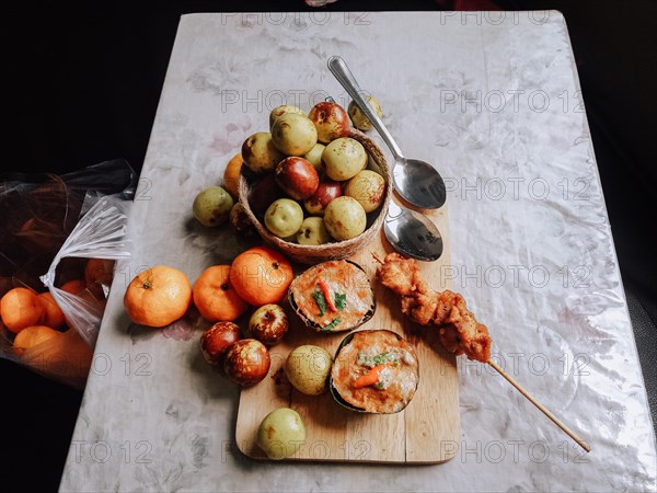 Haw mok or thai steamed red curry custard with clementine oranges and jujube fruit on a table