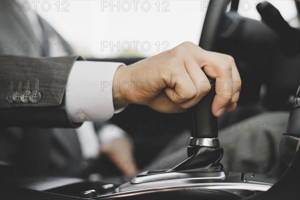 Close up businessman s hand gripping gear car