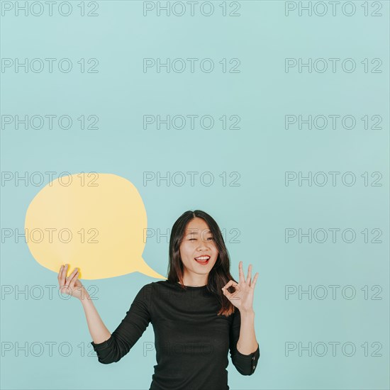 Winking woman with speech bubble gesturing ok