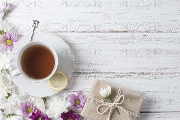 Overhead view lemon tea cup decorated with flowers gift box wooden desk