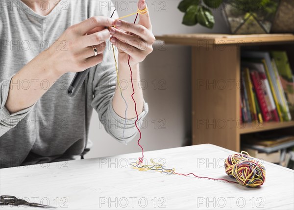 Female hands knitting with colorful thread