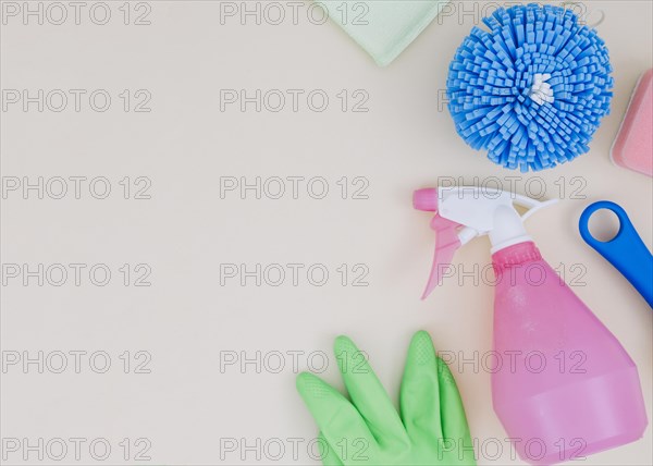 Overhead view spray bottle green gloves sponge white backdrop