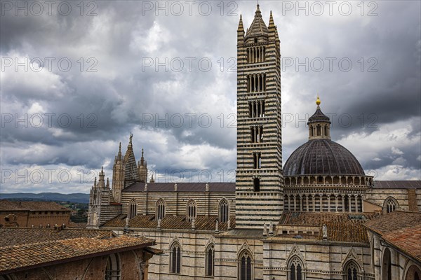 Dark clouds over the Siena Cathedral with its black and white striped marble facade