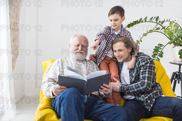 Multigenerational men watching album