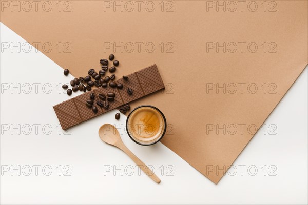 Roasted coffee beans chocolate bar coffee glass with spoon background