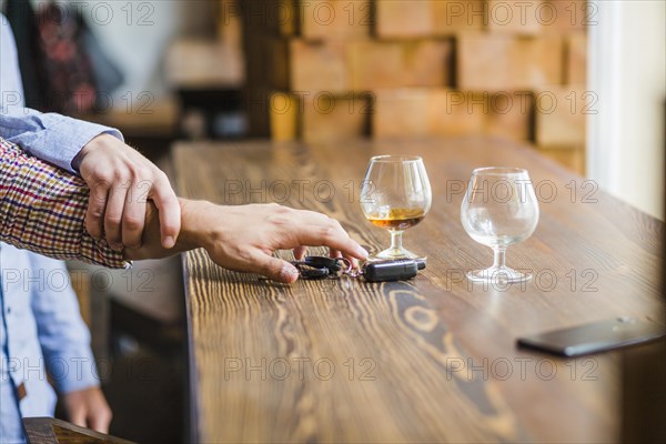 Man avoiding her friend taking car keys table