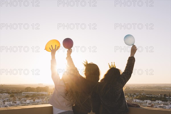 Anonymous girls with balloons roof