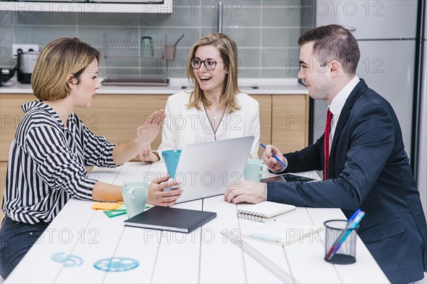 Cheerful colleagues using devices