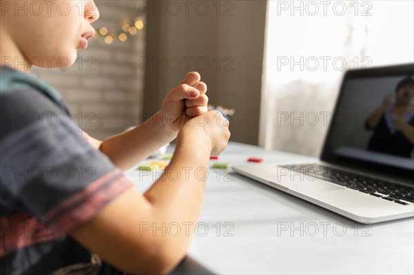 Boy talking with his teacher online school