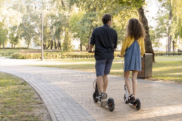 Cute young couple riding scooter outdoors