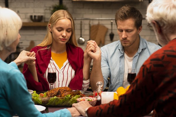 Family praying dinner table