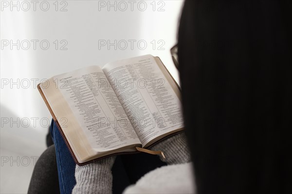 Woman reading bible indoors