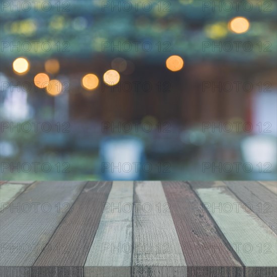 Wooden table top front garden with blurred bokeh lights