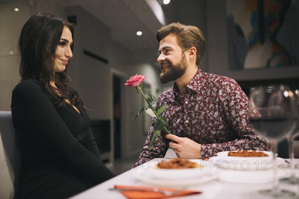 Man giving rose girl cafe