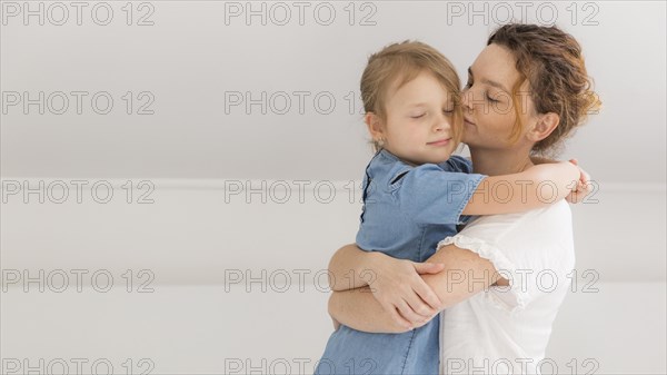 Mother hugging her little girl home
