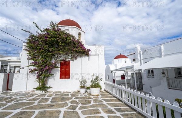White Greek Orthodox Church of St Nicholas with red roof and bougainvillea