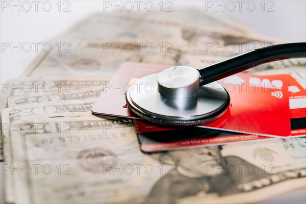 Stethoscope on credit card with dollar bills. Concept of online medical payments with credit card. Stethoscope with bank notes and credit card