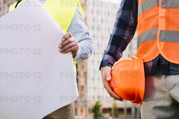 Close up men with safety vests helmet