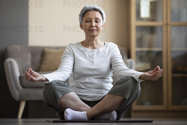 Mature woman meditating home