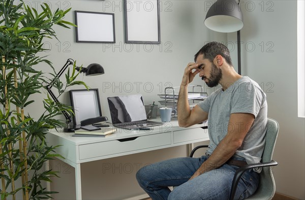 Tired man sitting his home desk