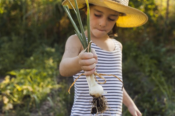 Portrait girl holding harvested spring onion