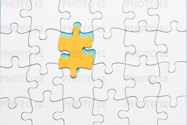 Yellow puzzle piece with white grid puzzle