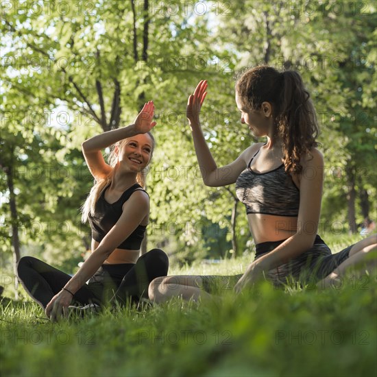 Young friends doing yoga park