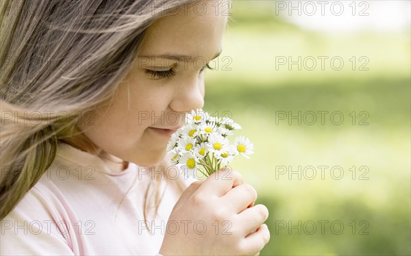 Close up girl smelling bouquet field flowers
