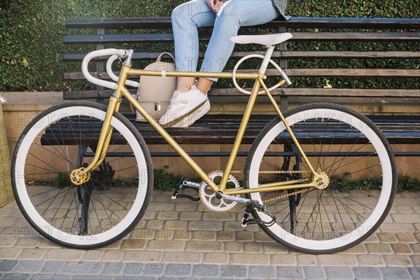 Crop woman sitting bench bicycle