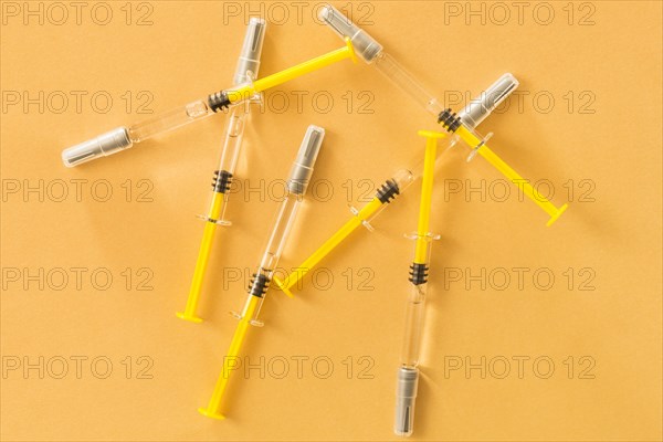 Elevated view medical syringes yellow background