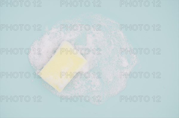 Overhead view sponge with sud blue background