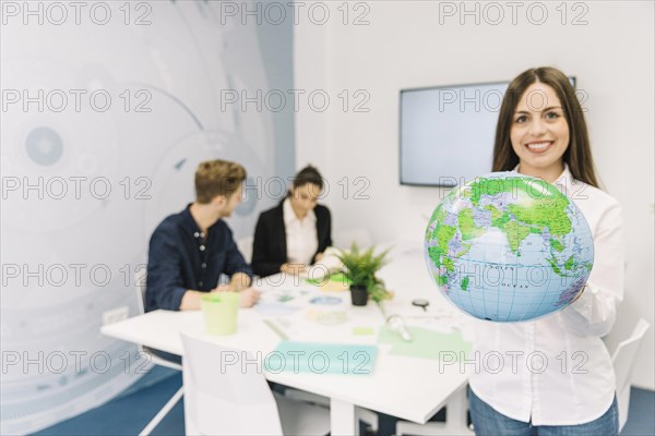 Portrait happy businesswoman holding globe