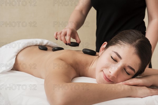 Woman enjoying hot rocks therapy spa