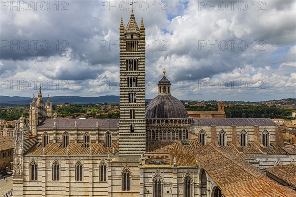 Dark clouds over the Siena Cathedral with its black and white striped marble facade