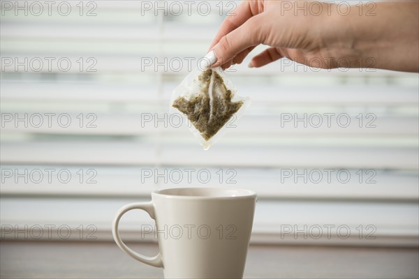 Hand holding tea bag