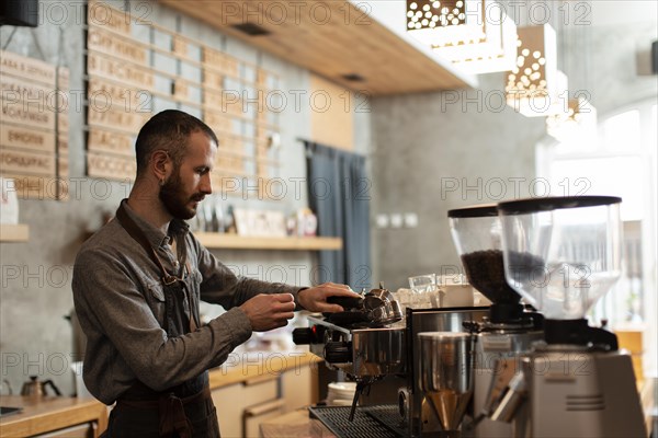 Side view man working coffee shop