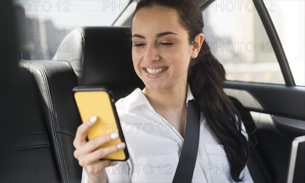 Passenger using her mobile phone car