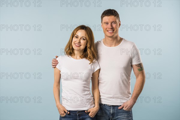 Portrait smiling young couple against blue background