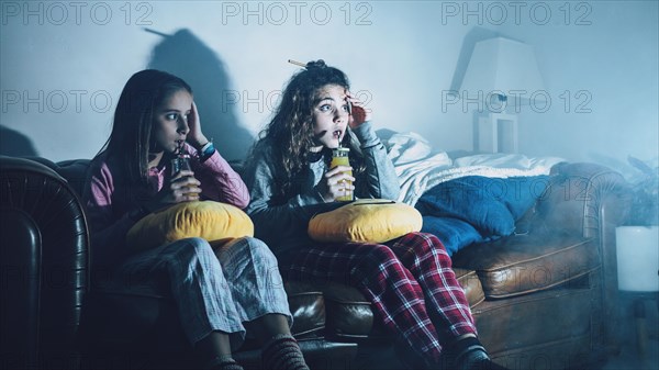 Scared kids with juice watching tv