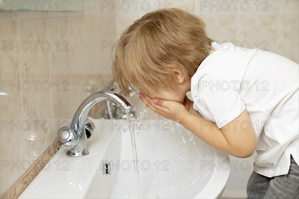 Side view boy washing his face