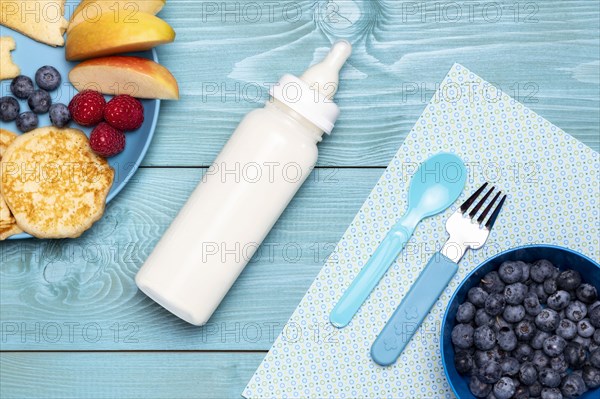 Top view baby bottle with blueberries food